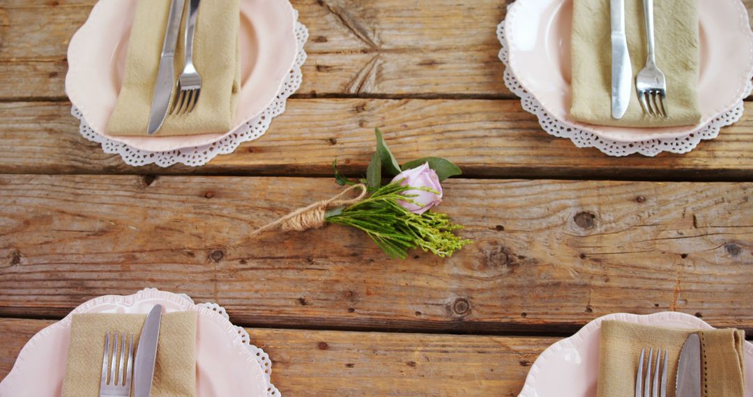 An elegant rustic table setting combines fine cutlery, pink plates, and floral decor. - Free Images, Stock Photos and Pictures on Pikwizard.com