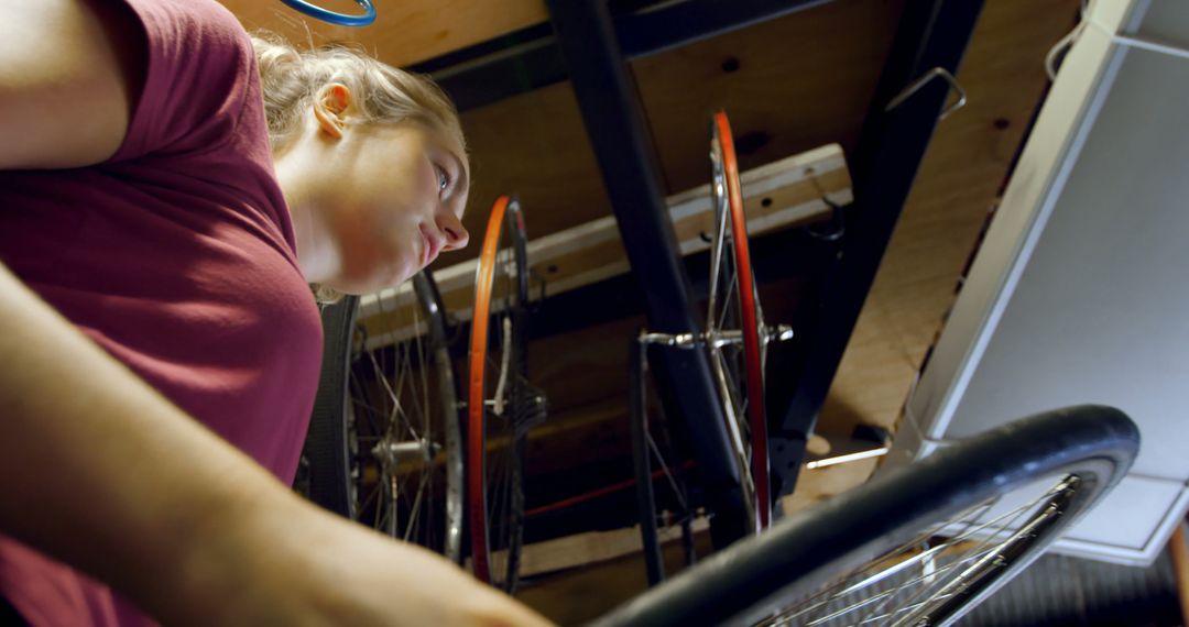 Young Woman Repairing Bicycle in Garage - Free Images, Stock Photos and Pictures on Pikwizard.com