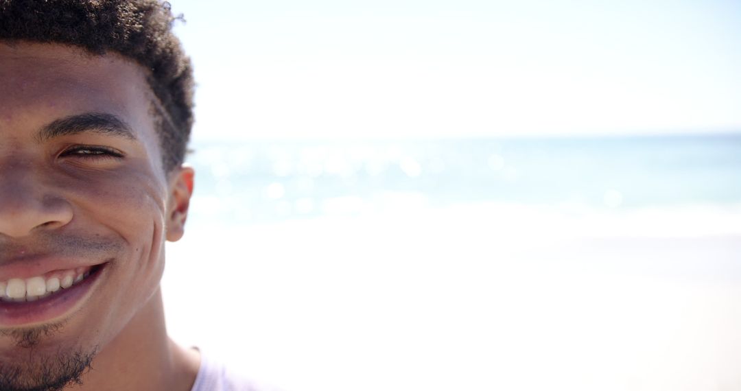 Happy Young Man Smiling on a Sunny Beach Day with Copy Space