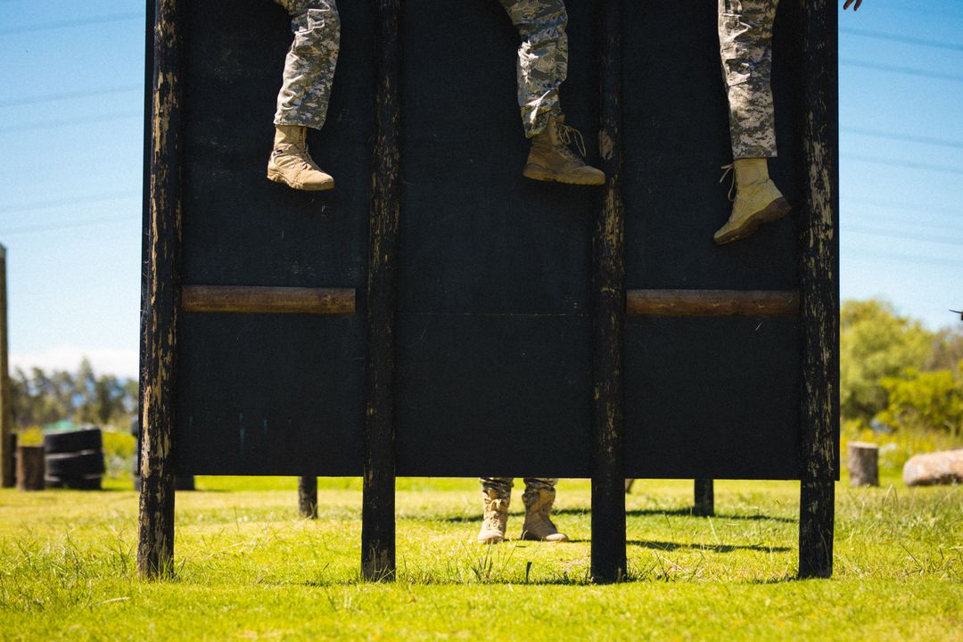 Low section of multiracial mid adult male and female soldiers on wooden obstacle during training - Free Images, Stock Photos and Pictures on Pikwizard.com