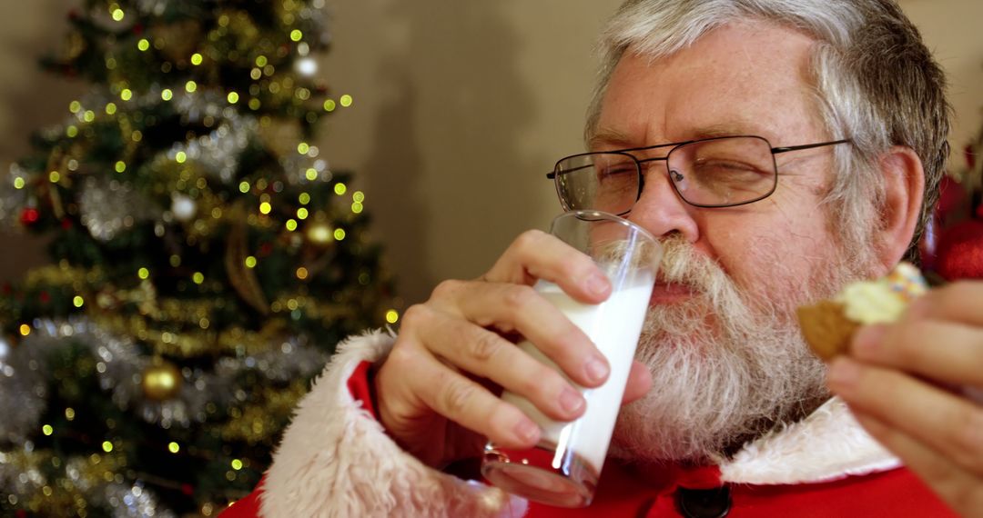 Santa Claus Enjoying Milk and Cookies by Christmas Tree - Free Images, Stock Photos and Pictures on Pikwizard.com