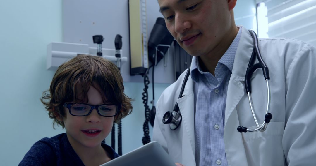 Doctor and Young Boy Interacting with Tablet in Medical Office - Free Images, Stock Photos and Pictures on Pikwizard.com