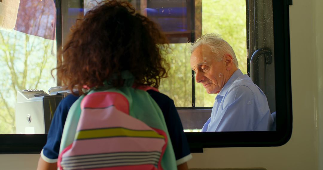 Girl speaking to elderly ticket inspector on transportation - Free Images, Stock Photos and Pictures on Pikwizard.com