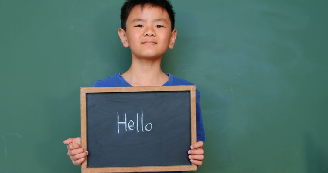 Schoolboy Holding Chalkboard with Hello Message in Classroom