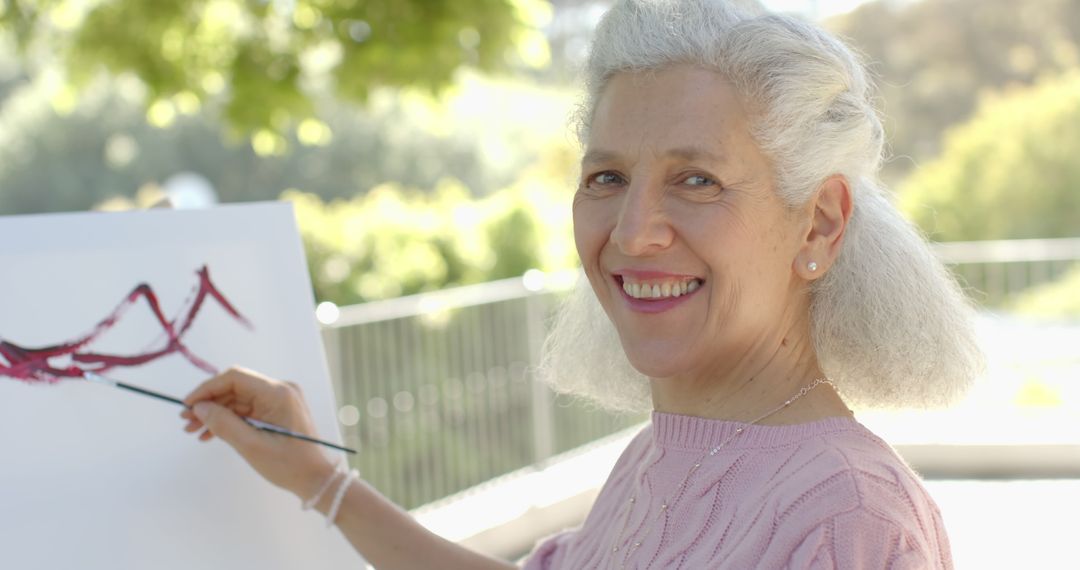 Elderly Woman Smiling While Painting Outdoors - Free Images, Stock Photos and Pictures on Pikwizard.com