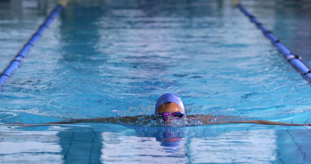 Competitive Swimmer Doing Breaststroke in Indoor Pool Lane - Free Images, Stock Photos and Pictures on Pikwizard.com