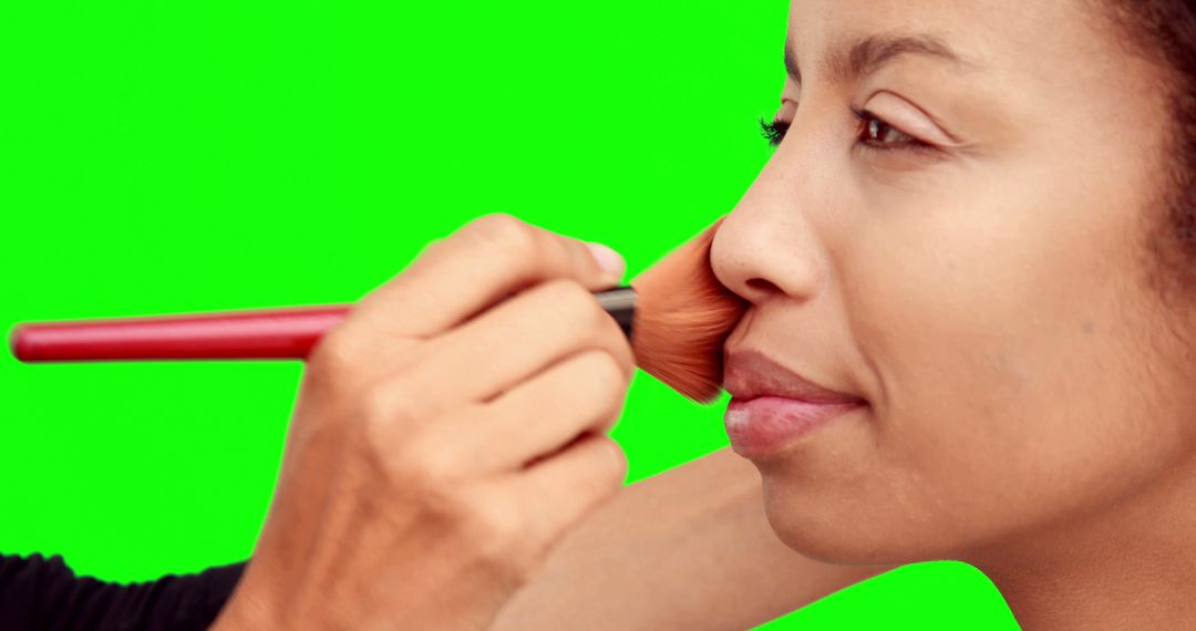 Makeup Artist Applying Blush to Model Face on Green Screen