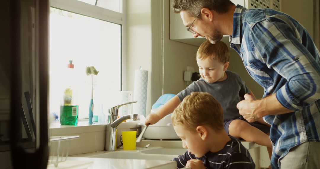 Father Teaching Two Sons to Wash Dishes by Kitchen Sink - Free Images, Stock Photos and Pictures on Pikwizard.com