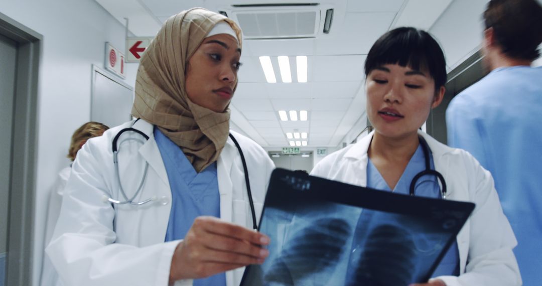 Female Doctors Discussing X-Ray in Hospital Corridor - Free Images, Stock Photos and Pictures on Pikwizard.com