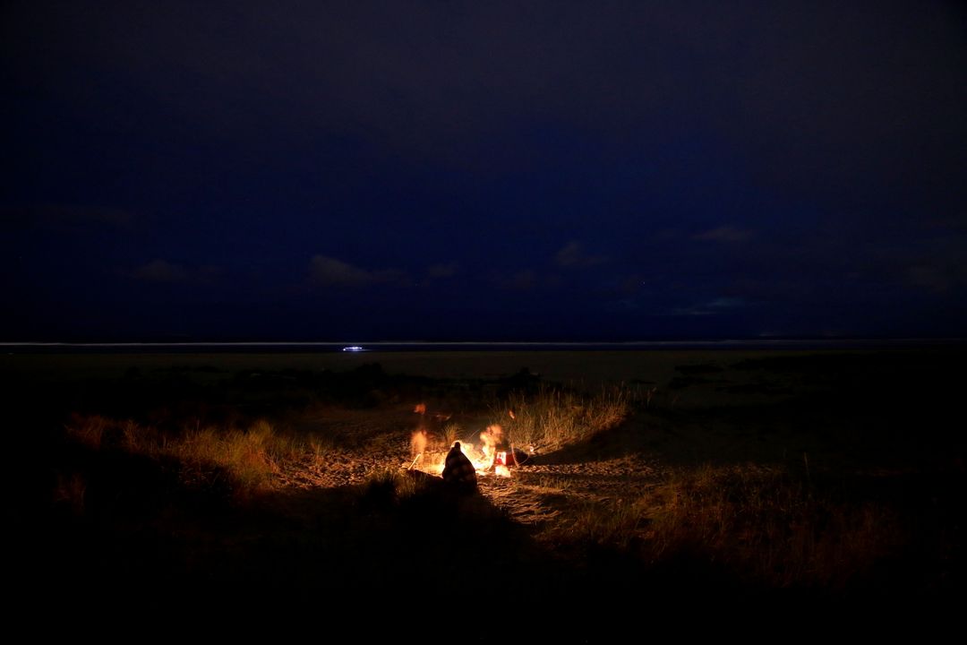 Group Sitting Around Campfire on Beach at Night - Free Images, Stock Photos and Pictures on Pikwizard.com