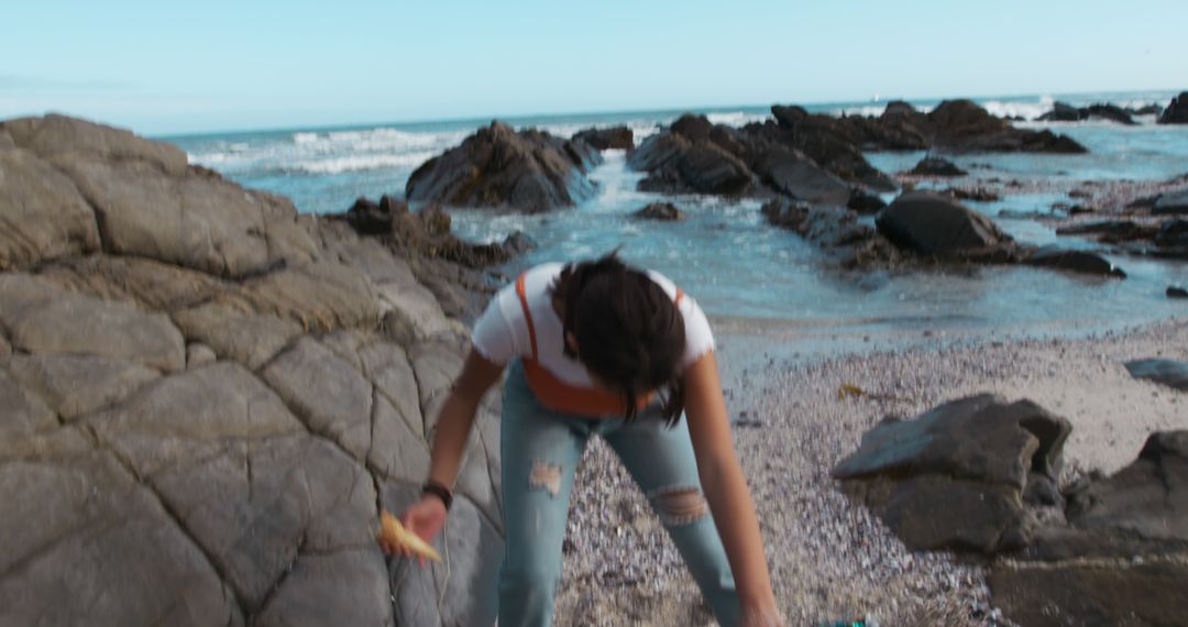 Person Enjoying Outdoor Picnic by Rocky Seaside with Sparse Waves - Free Images, Stock Photos and Pictures on Pikwizard.com