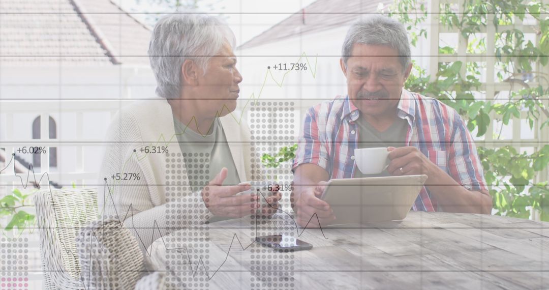 Senior Couple Enjoying Coffee While Engaging with Digital Data Indoors