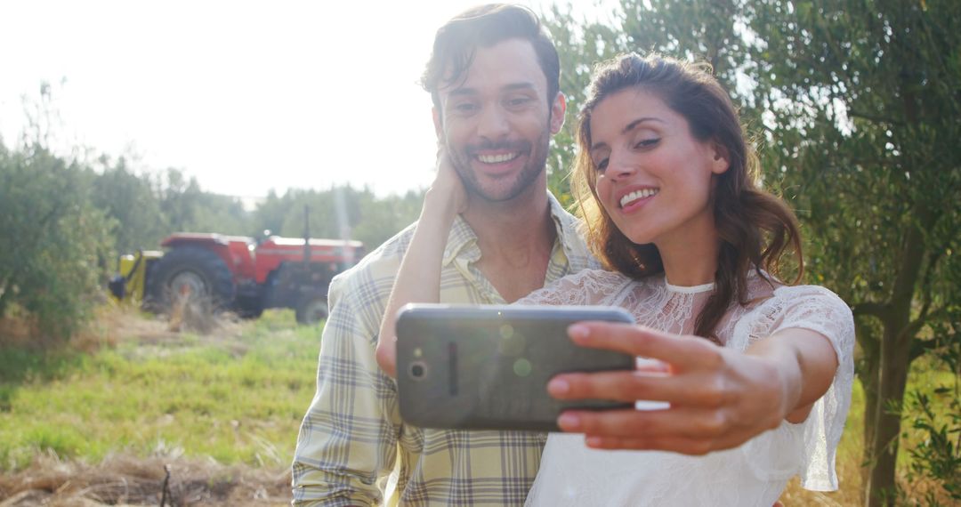 Joyful Couple Taking Selfie in Sunny Orchard