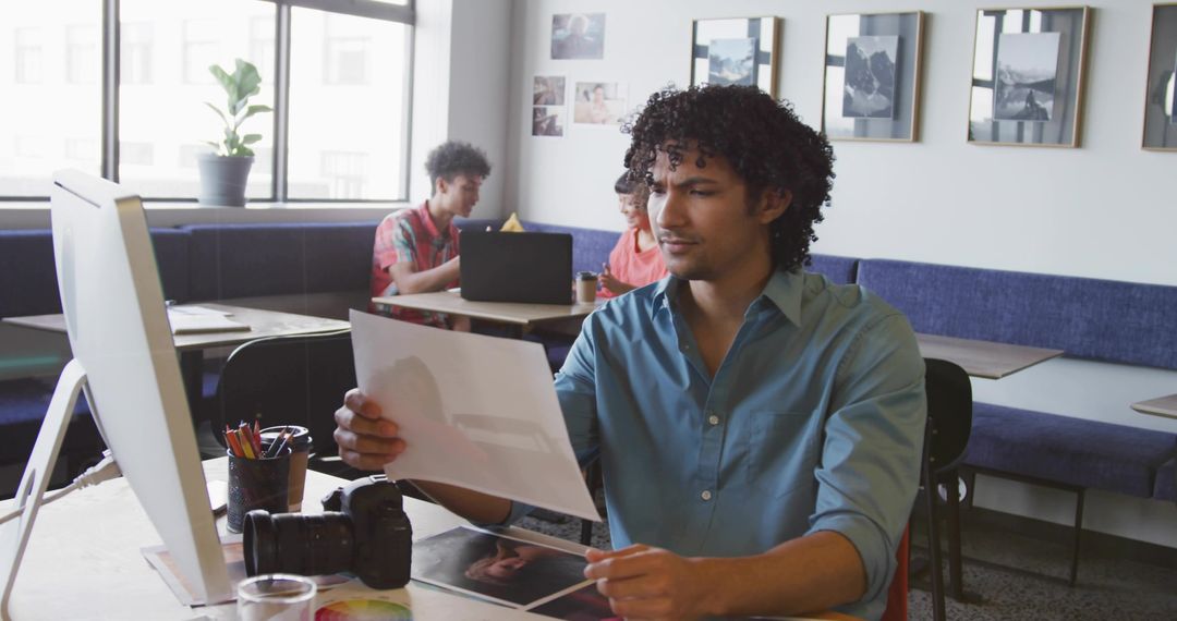 Man Reviewing Photographic Print in Modern Coworking Studio
