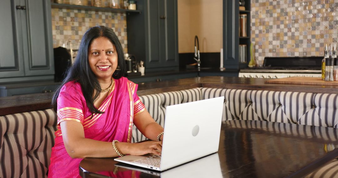 Indian Woman in Sari Using Laptop in Kitchen, Work from Home Environment