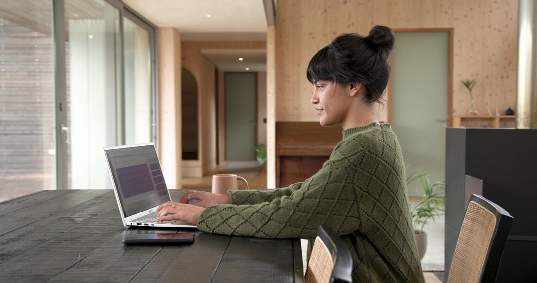 Asian Woman Working on Laptop in Cozy Minimalist Setting