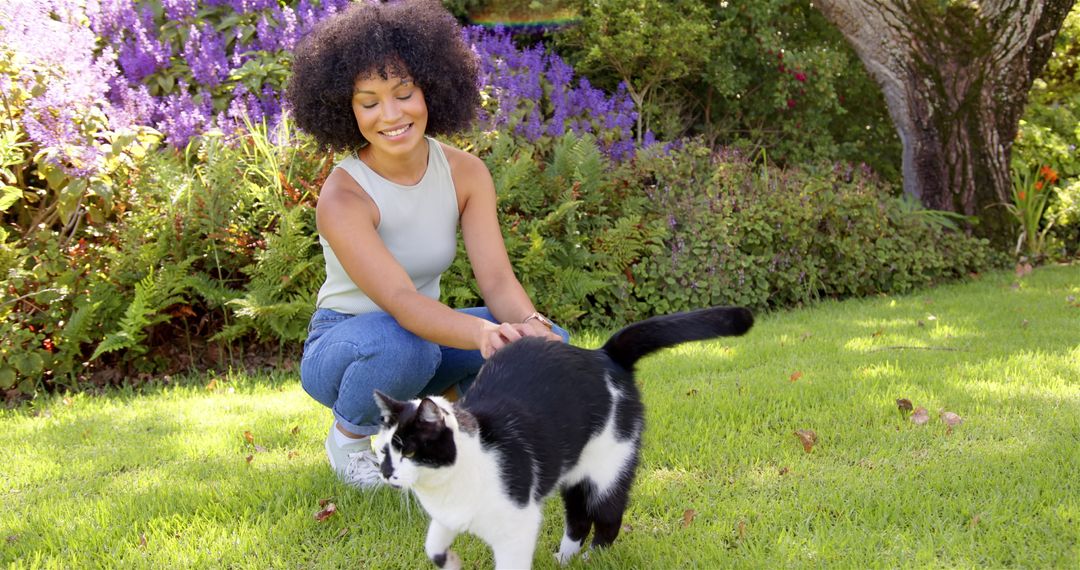 Woman Enjoying Leisurely Afternoon with Black and White Cat in Garden