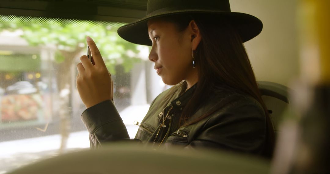 Young Woman in Stylish Hat Using Smartphone on Public Transport - Free Images, Stock Photos and Pictures on Pikwizard.com