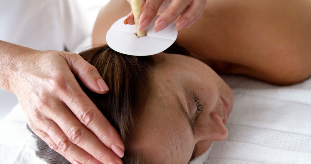 Therapist Performing Ear Candling on Woman in Spa - Free Images, Stock Photos and Pictures on Pikwizard.com