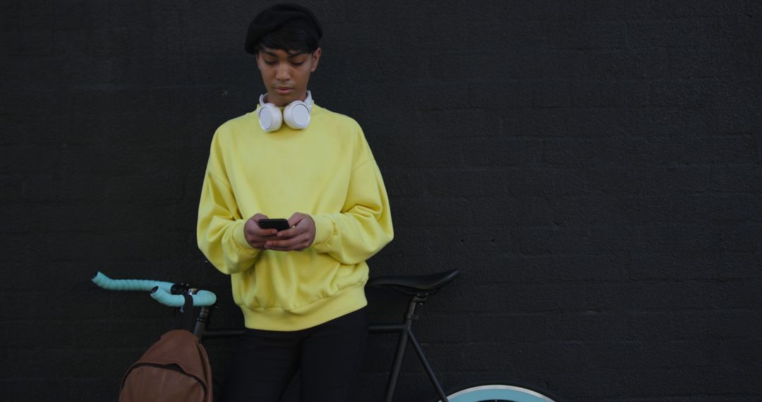 Modern Man in Yellow Sweater Using Smartphone by Bike