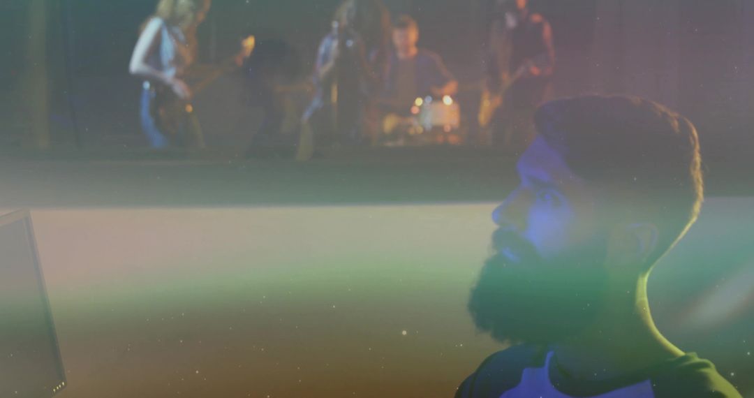 Bearded Man Watching Rock Band Performance on Monitor