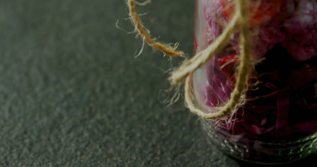 Rustic Glass Jar with Purple Botanicals and Twine on Dark Countertop
