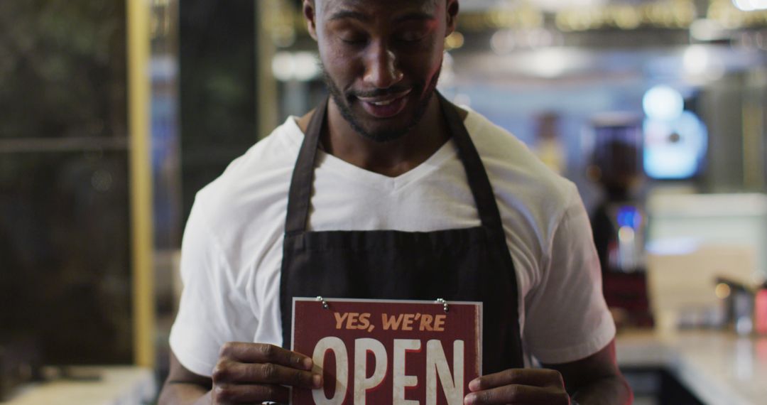 Smiling Barista Displaying Open Sign in Coffee Shop