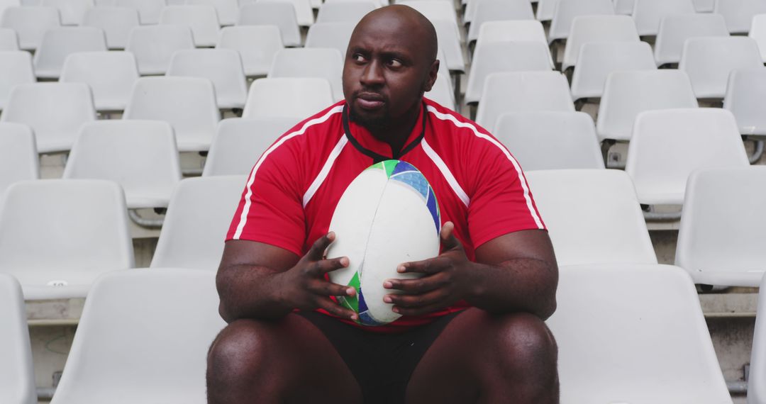 Rugby player sitting with ball in empty stadium - Free Images, Stock Photos and Pictures on Pikwizard.com