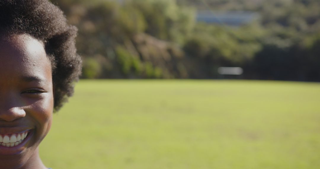 Smiling Child in Sunlit Field Reflecting Carefree Joy