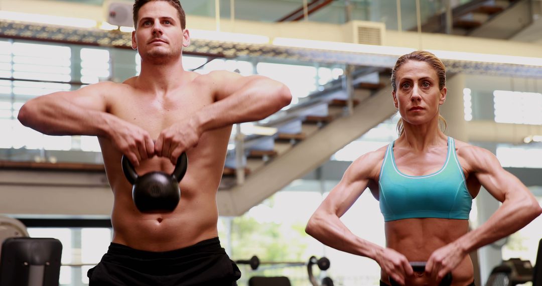 Fit Man and Woman Lifting Kettlebells in Gym - Free Images, Stock Photos and Pictures on Pikwizard.com