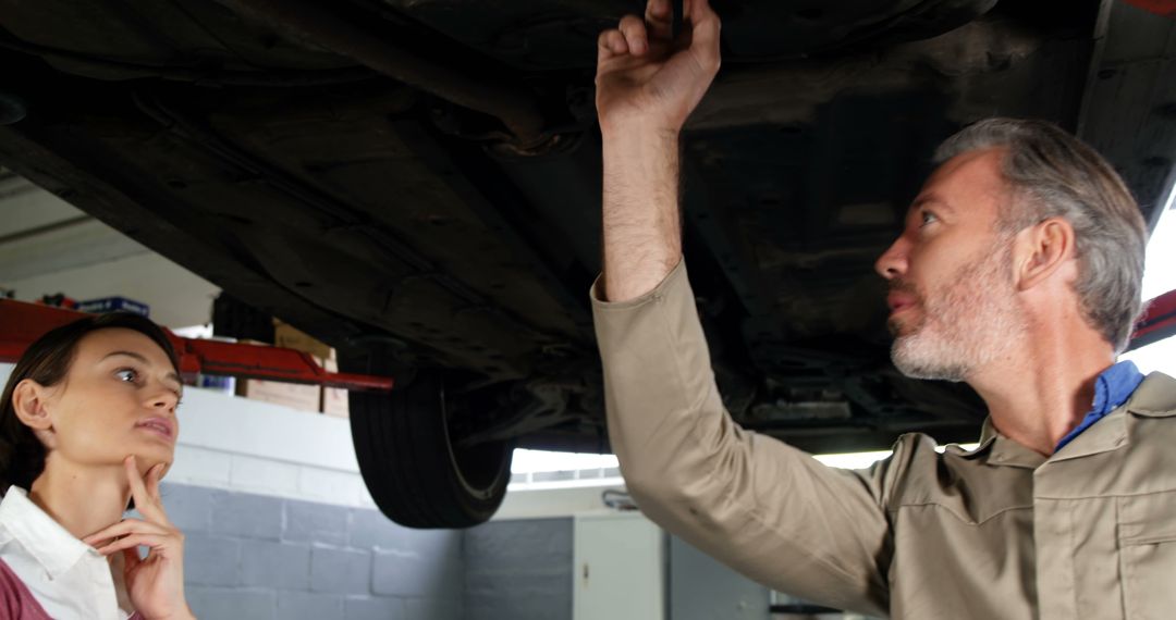 Mechanic Explaining Car Repairs to Female Customer in Workshop - Free Images, Stock Photos and Pictures on Pikwizard.com