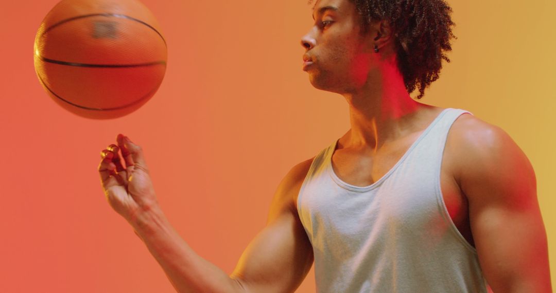 Image of biracial male basketball player with ball on orange to yellow background - Free Images, Stock Photos and Pictures on Pikwizard.com