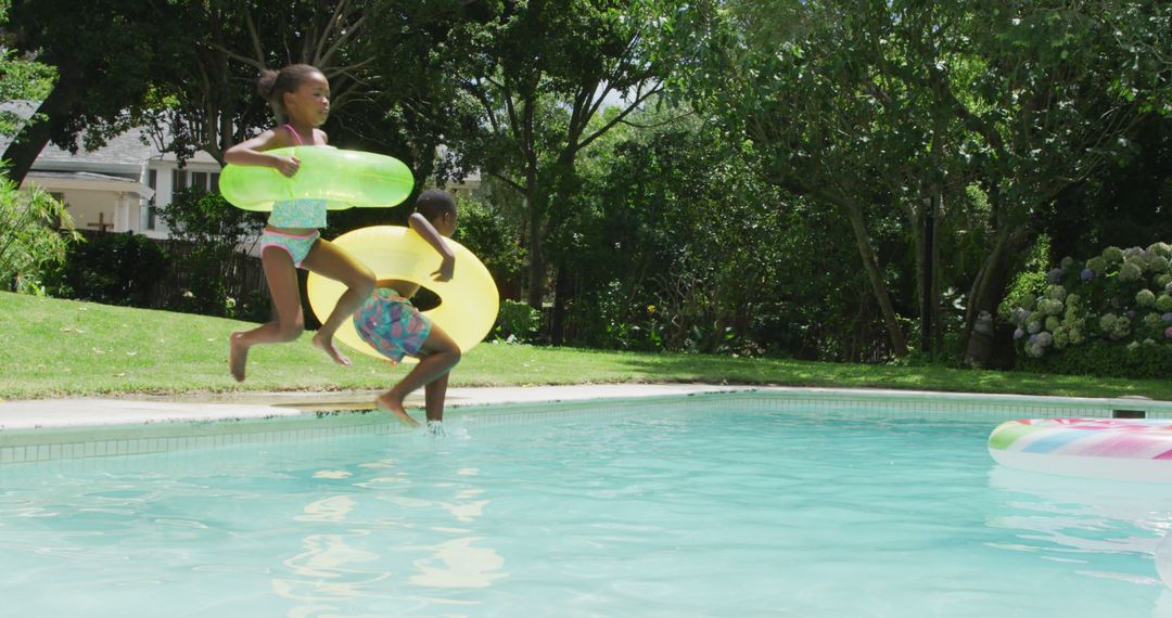 Children Jumping into Sunlit Pool with Inflatable Rings - Free Images, Stock Photos and Pictures on Pikwizard.com