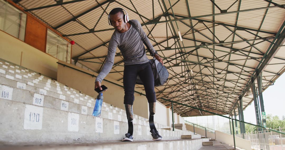 Focused Athlete with Prosthetic Legs Cleaning Stadium Stands - Free Images, Stock Photos and Pictures on Pikwizard.com