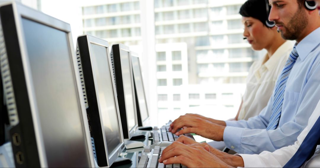 Focused Office Workers Typing at Desks in Modern Workspace