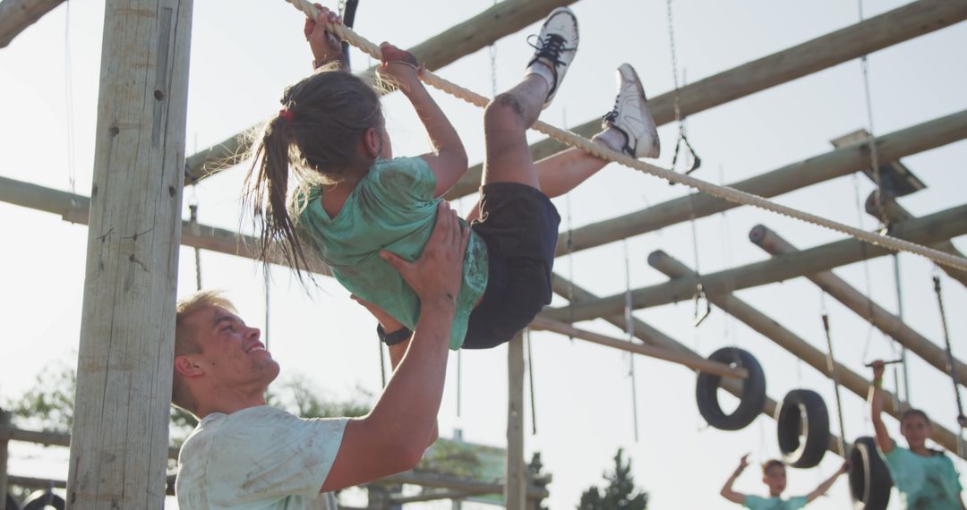 Instructor Guiding Youngster on Obstacle Course Rope Climb - Free Images, Stock Photos and Pictures on Pikwizard.com