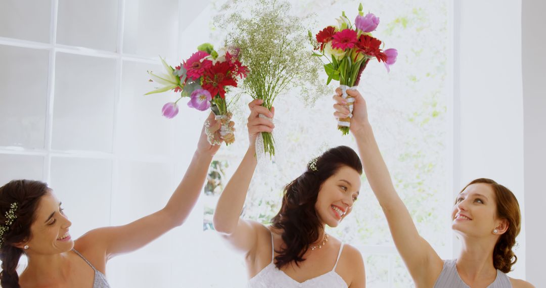 Bridesmaids Celebrating and Raising Bouquets in Bright Room - Free Images, Stock Photos and Pictures on Pikwizard.com