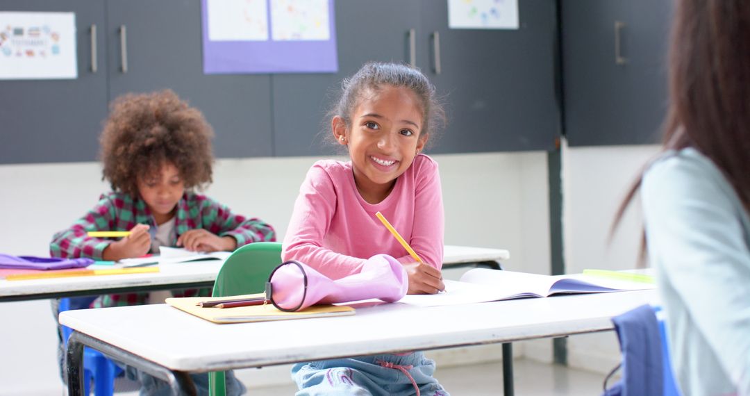 Smiling Girl Writing at Classroom Desk Enjoying School Time
