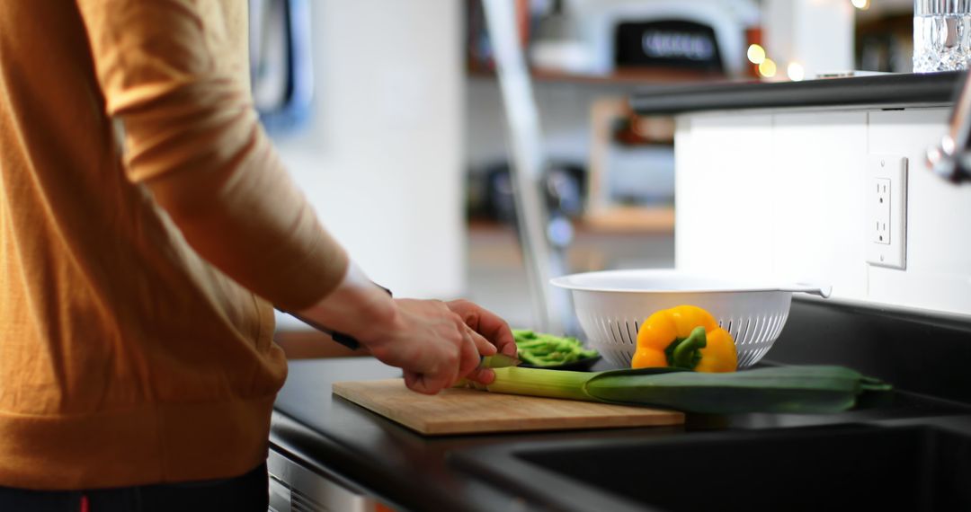 Person Chopping Vegetables on Cutting Board in Modern Kitchen - Free Images, Stock Photos and Pictures on Pikwizard.com