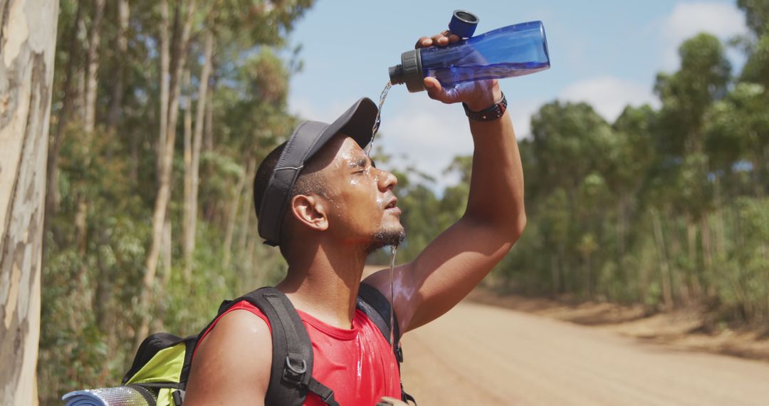 Man Hydrating While Hiking on Trail During Sunny Day - Free Images, Stock Photos and Pictures on Pikwizard.com