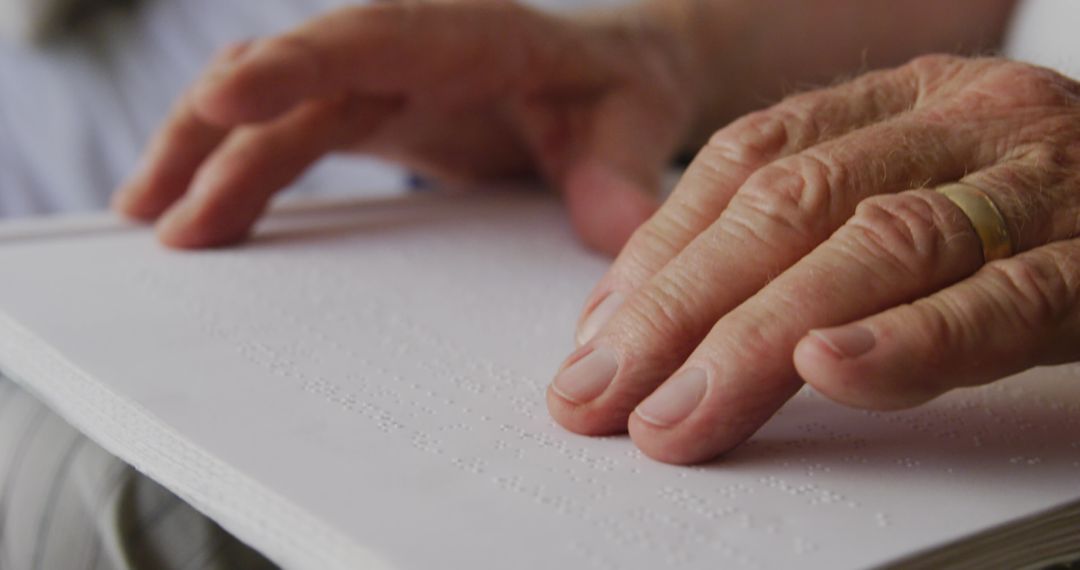 Senior Man Reading Braille Book at Retirement Home