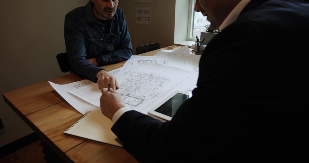 Architects Reviewing Building Plans in Modern Office
