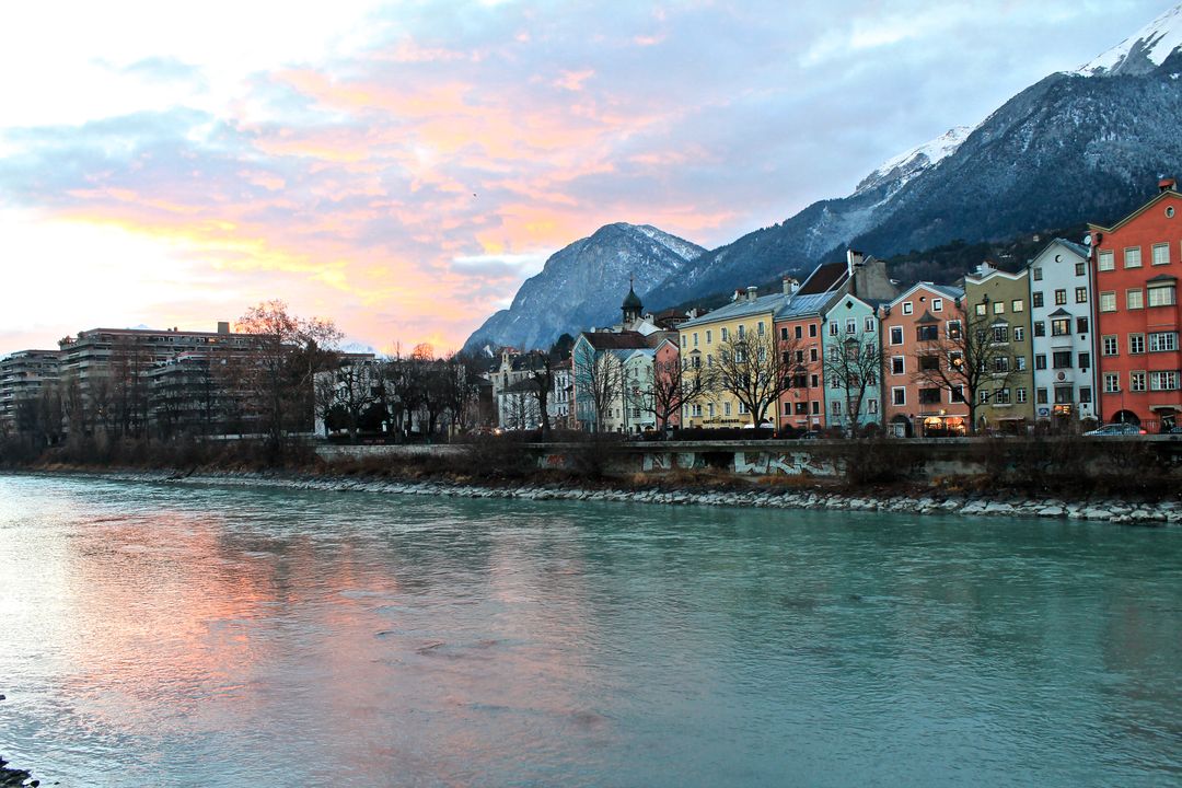 Colorful Buildings by River at Sundown in Innsbruck, Austria - Free Images, Stock Photos and Pictures on Pikwizard.com