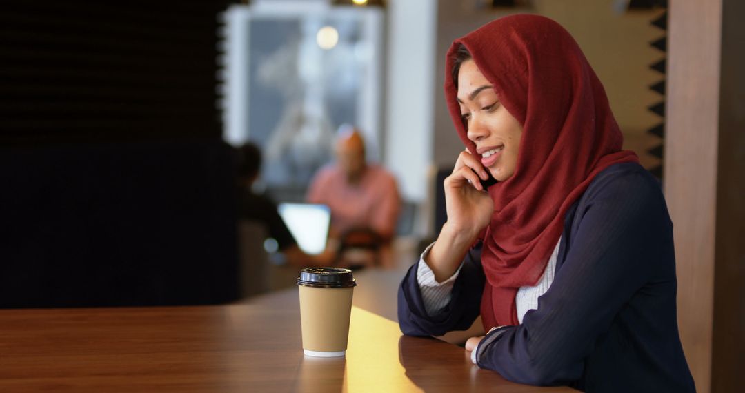 Muslim Woman in Hijab Talking on Phone at Cafe - Free Images, Stock Photos and Pictures on Pikwizard.com