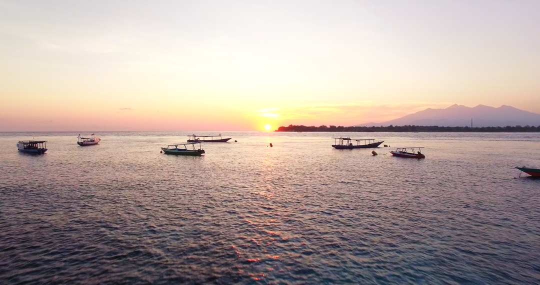 Transparent sunset over calm sea with boats floating quietly - Download Free Stock Images Pikwizard.com