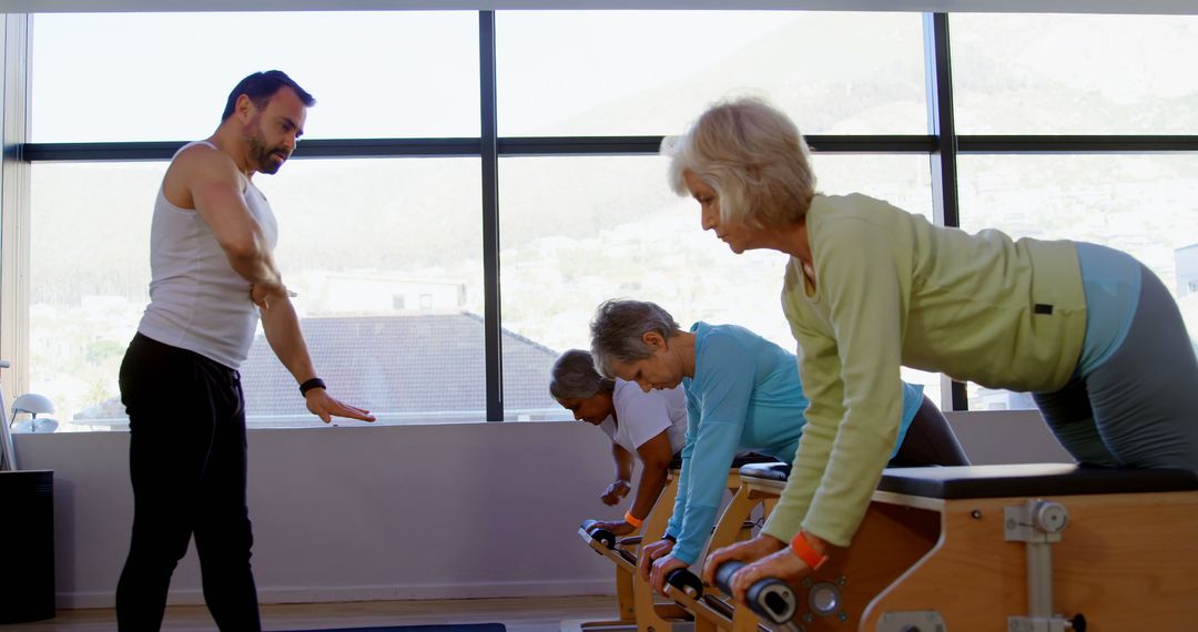 Senior Women Doing Pilates with Instructor in Fitness Studio - Free Images, Stock Photos and Pictures on Pikwizard.com