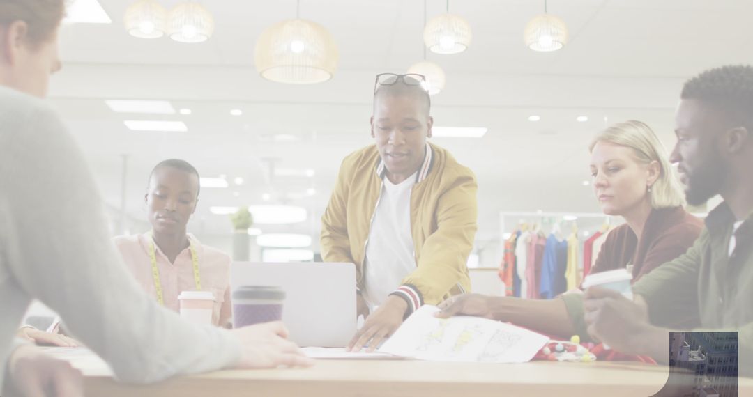 Creative Fashion Designers Collaborating Over Sketches in Studio