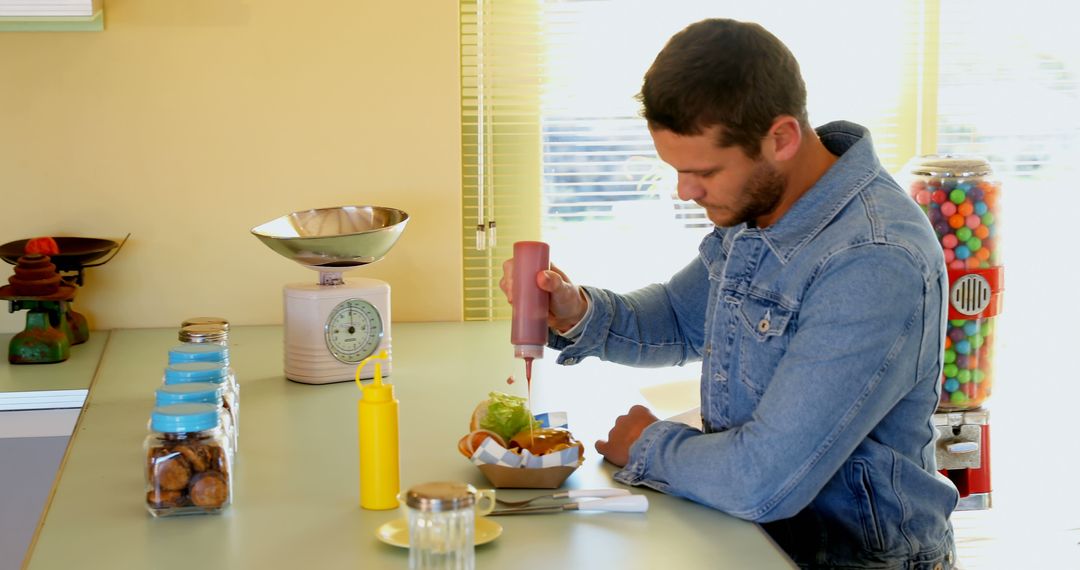 Man Adding Ketchup to Burger in Vintage Diner - Free Images, Stock Photos and Pictures on Pikwizard.com