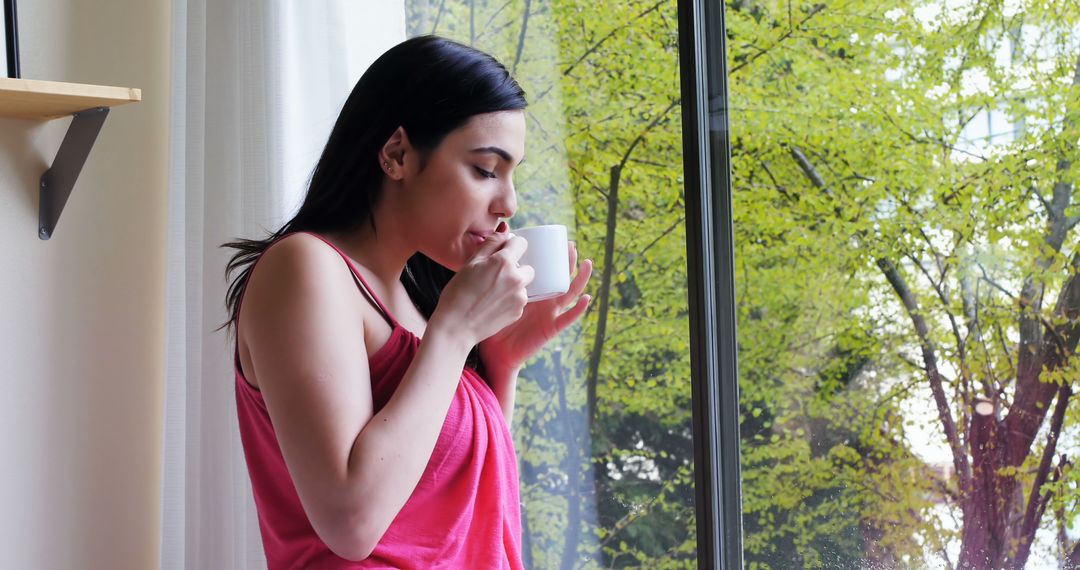 Young Woman Drinking Coffee at Home Near Window on Sunny Morning - Free Images, Stock Photos and Pictures on Pikwizard.com