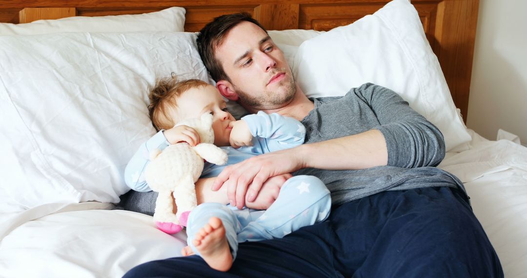 Father and Baby Relaxing on Bed in Casual Clothing - Free Images, Stock Photos and Pictures on Pikwizard.com